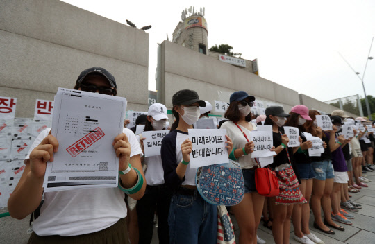 이화여대 미래라이프대학 산업에 반대하는 졸업생들이 2일 오후 서대문구 학교 정문 앞에서 졸업증서 반납 퍼포먼스를 하고 있다. 사진=연합뉴스